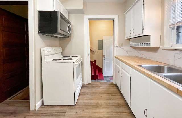Large, 5 bedroom Home with wood flooring and updated bathroom, close to campus with a fenced yard and fire pit. Gallery 4